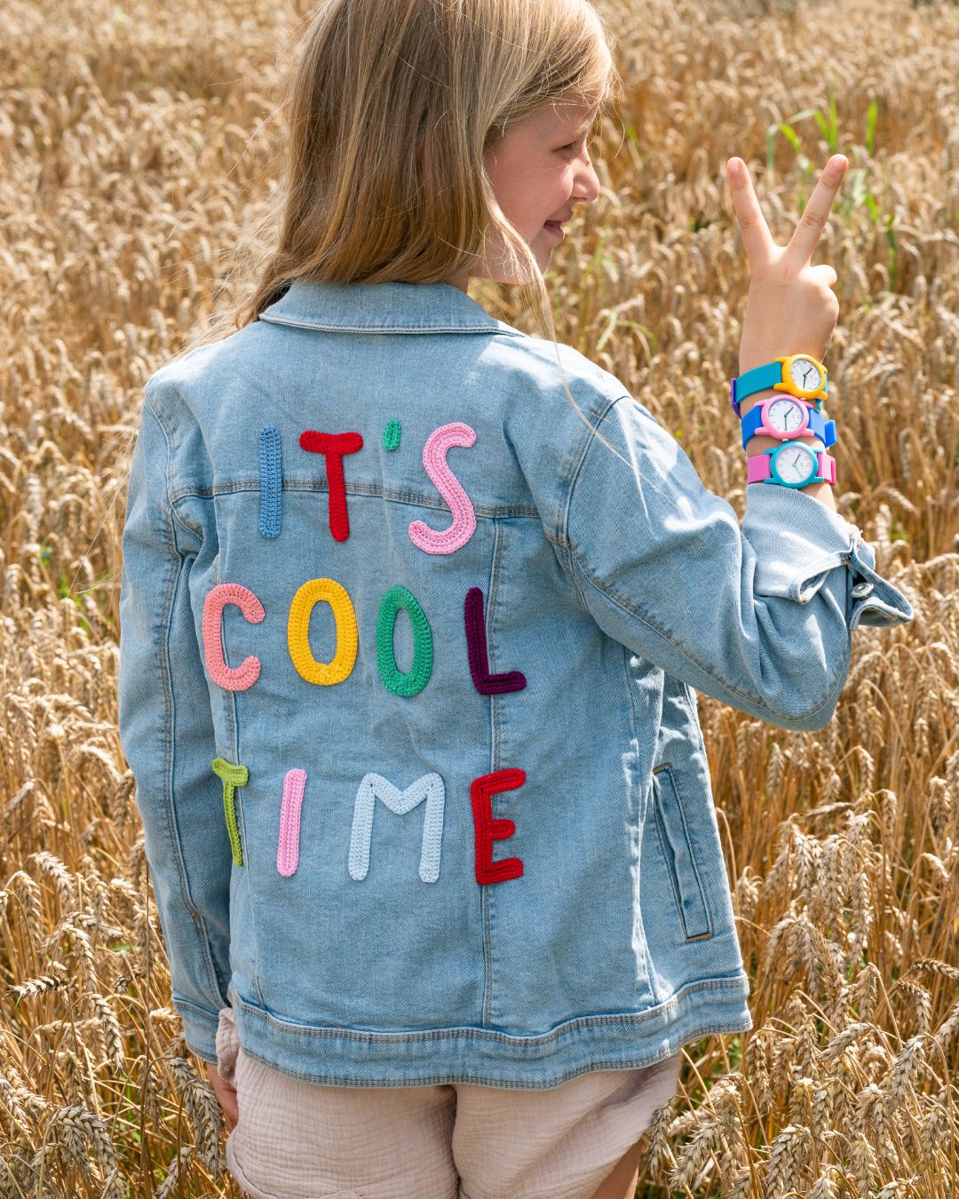 Kind in "It's Cool Time Jacke" und drei Cool Retro Uhren am Handgelenk